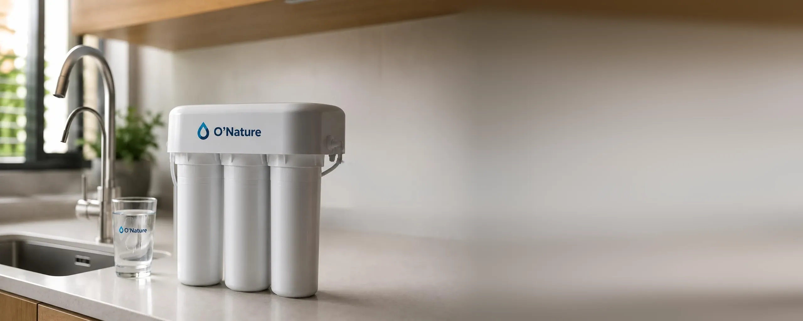 Système de filtration O'Nature relié à l'évier de la cuisine, avec un verre d'eau pure